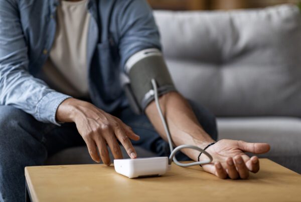 Cropped Of Young Black Man Checking Blood Pressure With Upper Arm Monitor