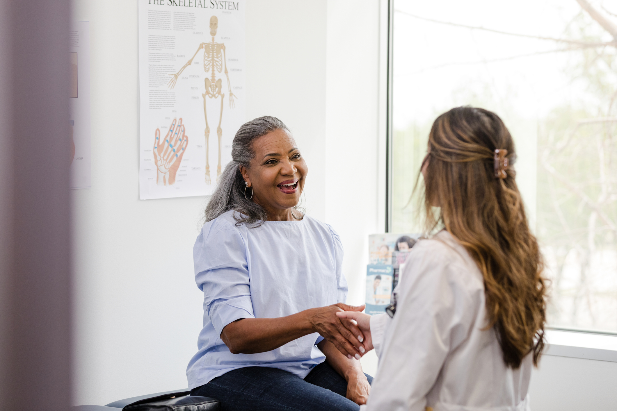 Female patient shakes hands with the female healthcare professional